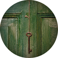 picture of an aged green door with a skeleton key hanging on a piece of twine or rope